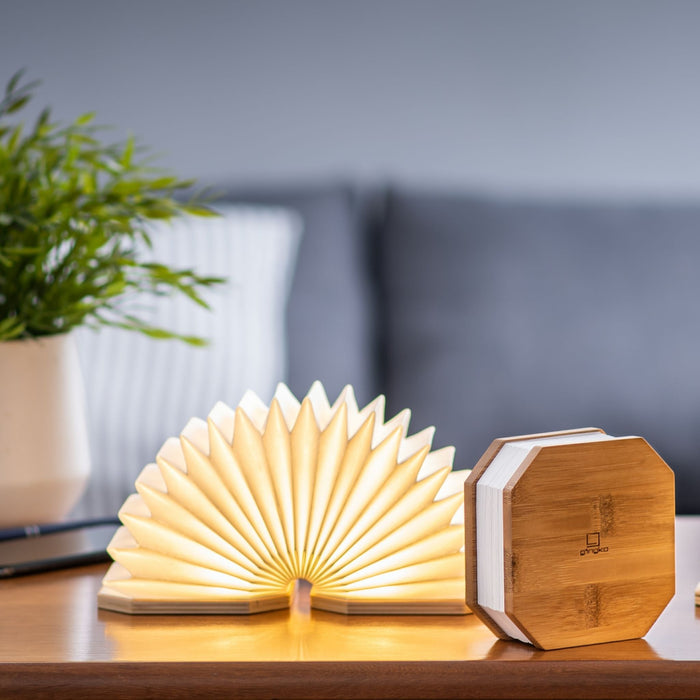 one illuminated gingko smart accordion light with a closed light next to it.