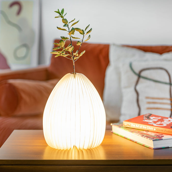 Gingko Design Smart Vase Open And Lit Up On A Coffee Table With Leafy Sprig Inside
