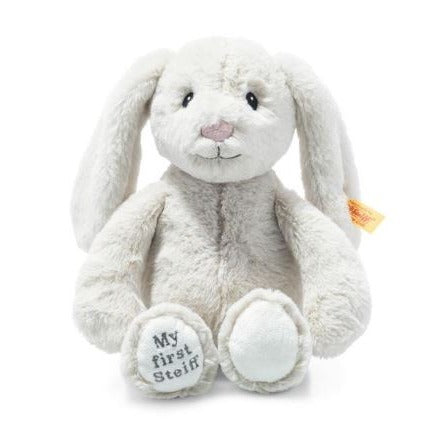 A light grey bunny rabbit called hoppie with a yellow steiff tag in the ear and 'my first steiff' embroidered on the foot. 