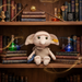 Plush Dobby toy on a shelf with books and magical items