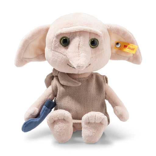 Plush toy resembling a creature with large ears and a small blue object, on a white background.