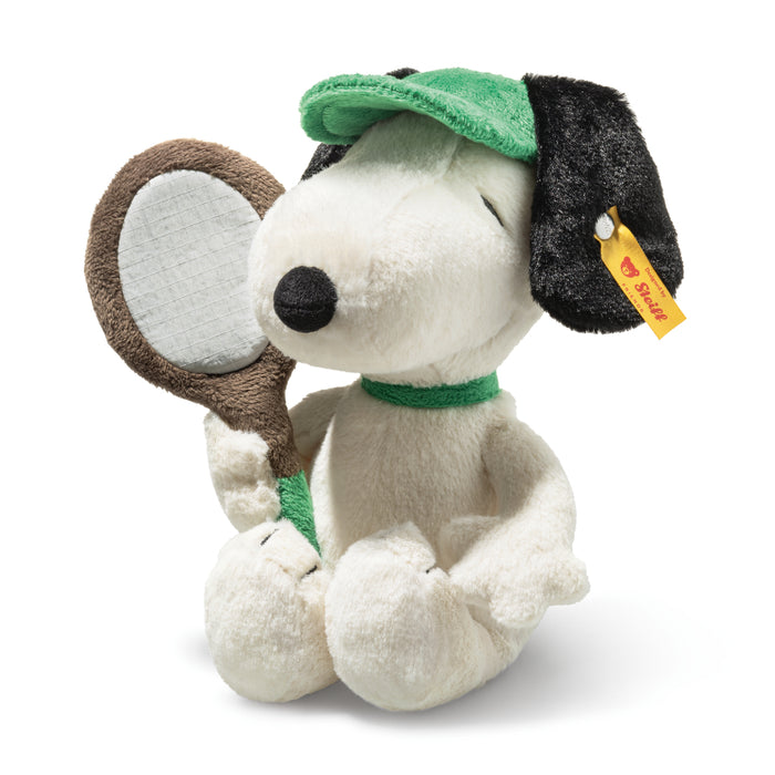 Plush toy resembling a dog with a green cap and racket on a white background