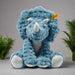 Blue plush triceratops toy with a visible brand tag on a white background