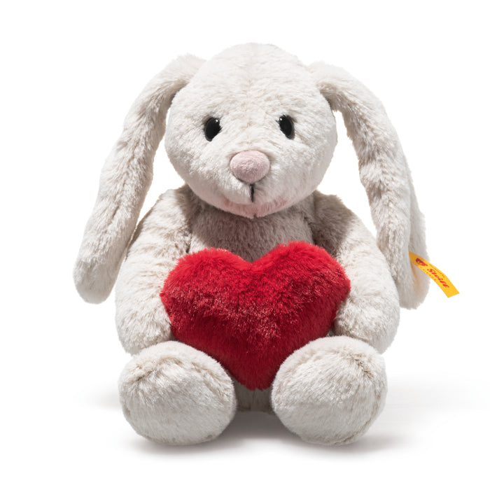 White plush bunny with a red heart and measurement label on a white background