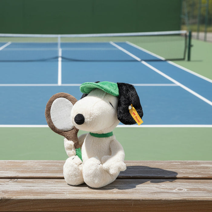 Buy Now Plush toy resembling a dog with a green cap and racket on a white background
