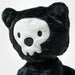 Black plush toy with skull face design on a white background