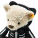 Plush bear toy in a skeleton costume with a visible Steiff tag on a white background