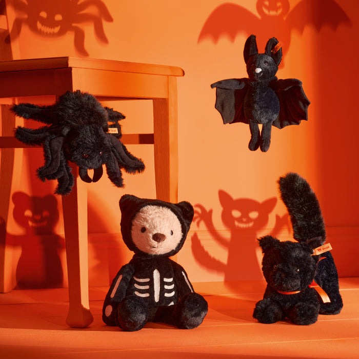 Halloween-themed plush toys on an orange background with spider and bat decorations.