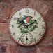 Decorative clock with a robin design on a brick wall