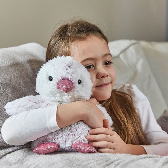 A little girl cuddling the pink marshmallow baby penguin. 