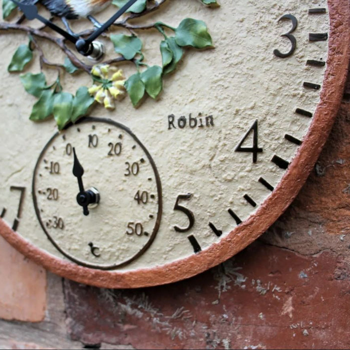 Decorative wall clock with floral design and thermometer on a rustic background