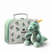 Green plush dinosaur toy with a matching suitcase featuring Steiff branding on a white background