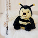 Bumblebee Warmies sitting on a cream fur swing