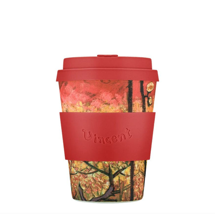 Reusable coffee cup with red lid and sleeve featuring a nature-themed design on a white background