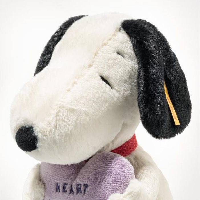 Plush dog toy with black and white face, red collar, and purple heart on a white background