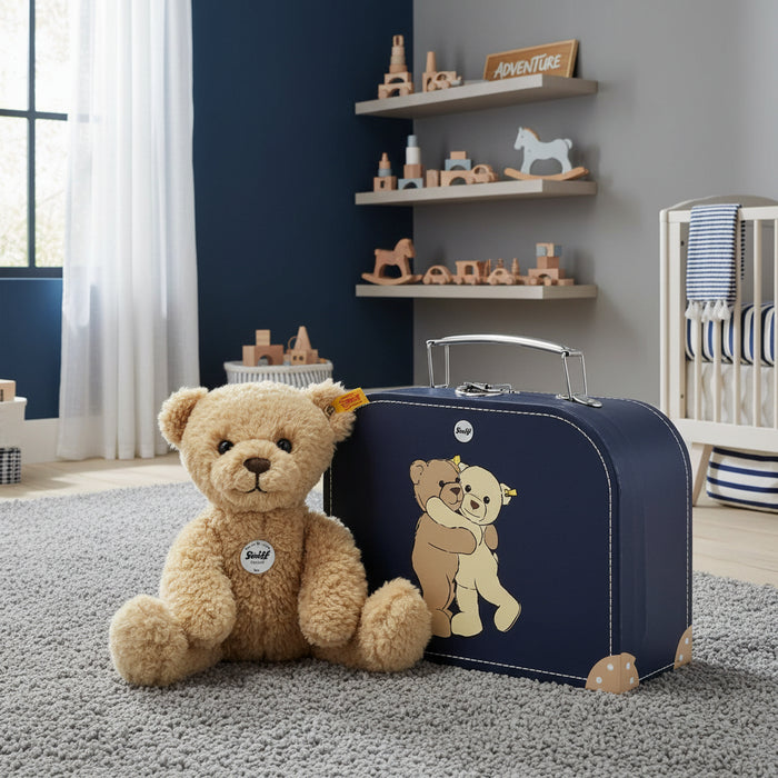Nursery room with a teddy bear and navy suitcase on a gray carpet