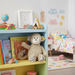 Children's room with a colorful bookshelf, teddy bear, and books.