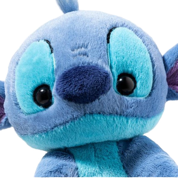 Close-up of a blue plush toy with large eyes on a white background