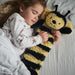 Little girl hugging her bumble bee hot water bottle whilst asleep. 