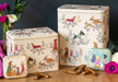 Decorative tins with animal illustrations on a wooden surface with flowers and treats.