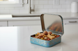Small blue tin box with pet treats on a kitchen counter