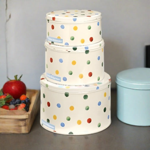 Trio of round off white stacked cake tins with a pastel coloured polka dot design repeated all over the tins, with a light blue Emma Bridgwater label printed on each tin .