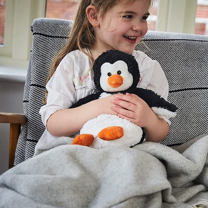 A little girl cuddling the Warmies Penguin 