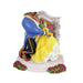 Belle is presented in her iconic yellow ball gown. With the beast in his blue long tailed suit jacket, whilst the duo stand in front of the stained glass window dancing. They are surrounded by red roses.