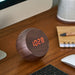 Tumbler Alarm Clock By Gingko In Walnut On A Work Desk Showing Digital LED Display
