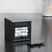 Gingko Cube LED clock in black showing the battery compartment open with batteries inside