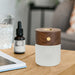 gingko american walnut effect smart diffuser with a small bottle of essential oil in the background