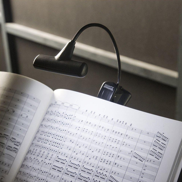 mightybright hammerhead music light in black being used to illuminate a book of sheet music