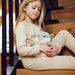 young girl sitting with grey hamster microwavable toy wheat filled with lavender scent