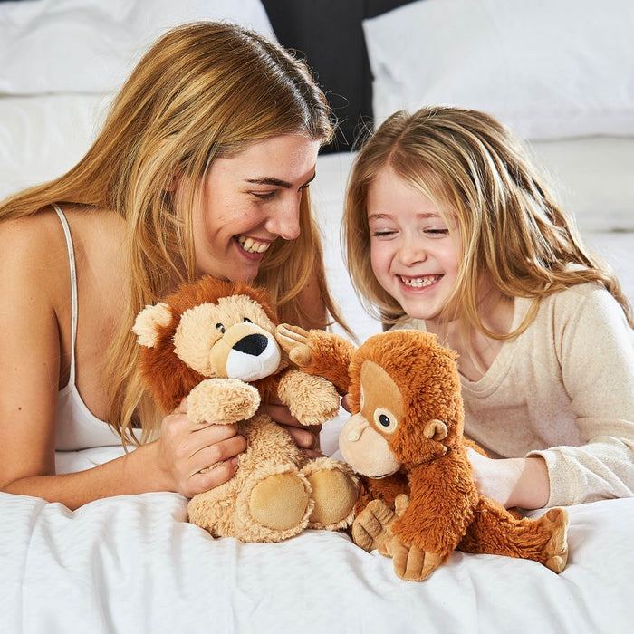 woman and young girl holding microwavable 13" lion soft toy and 13" orangutan toy
