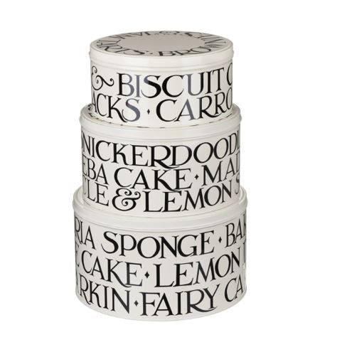 A stack of three off white coloured Emma Bridgewater Cake tins with black lettering that spells out some classic cakes and sweet treats repeated around the sides.
