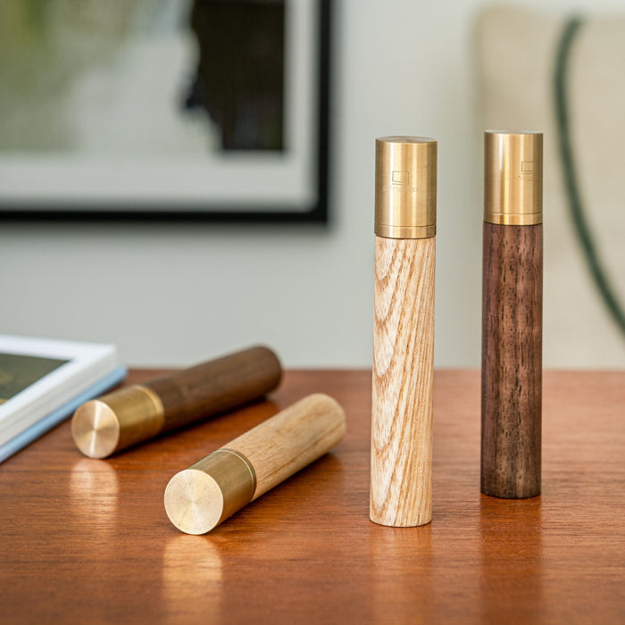two gingko natural wood flameless lighters in american walnut and white ash colours, with two more lighters lay next to them