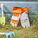 Red/Orange children gardening gloves in a garden setting 