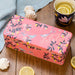 Sara Miller Orchard Pink Coral Tin Set On A Wooden Surface With Decorative Lemon Slices & Meringue
