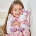 young girl holding Warmies pink sparkly unicorn heatable soft toy