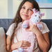 Young girl holding Warmies pink unicorn hot water bottle