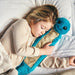 young girl sleeping with Warmies blue caterpillar hot water bottle