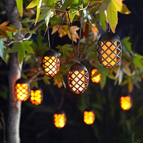 Black Smart Garden solar powered cool flame string lights displayed on trees at night in garden.