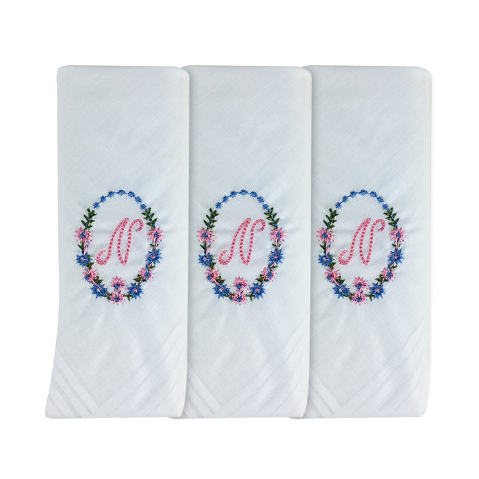 Three pack of white handkerchiefs displaying an embroidered letter N in pink with a floral boarder around the letter.