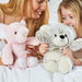 woman and young girl holding warmies pink elephant and teddy bear heat-up soft toys