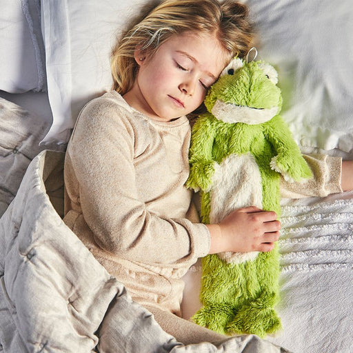 Young girl sleeping with huggable frog hot water bottle 