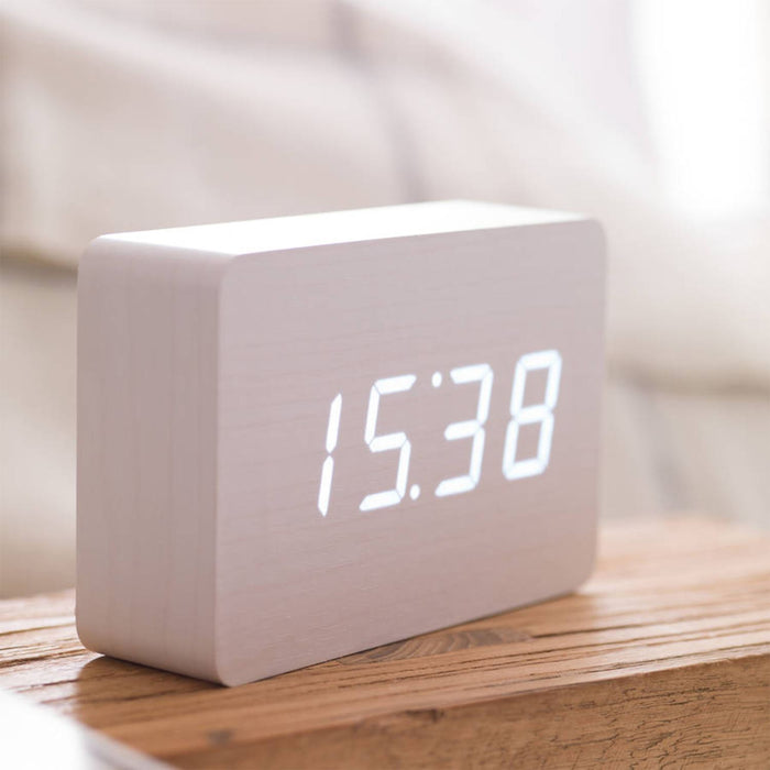 Side view of Gingko brick LED click clock in a white coloured wooden effect displaying the time in bright white