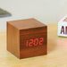 Gingko Cube LED click clock in a walnut effect displaying the time in red