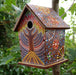 A bright multi-coloured painted dot mosaic bird house. 